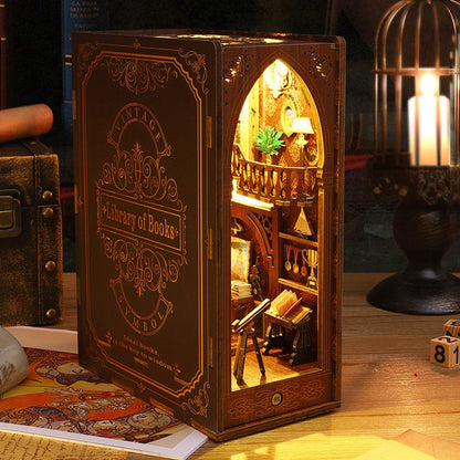 May include: A wooden book-shaped box with a miniature library scene inside. The box is decorated with gold accents and the words "Vintage Library of Books".