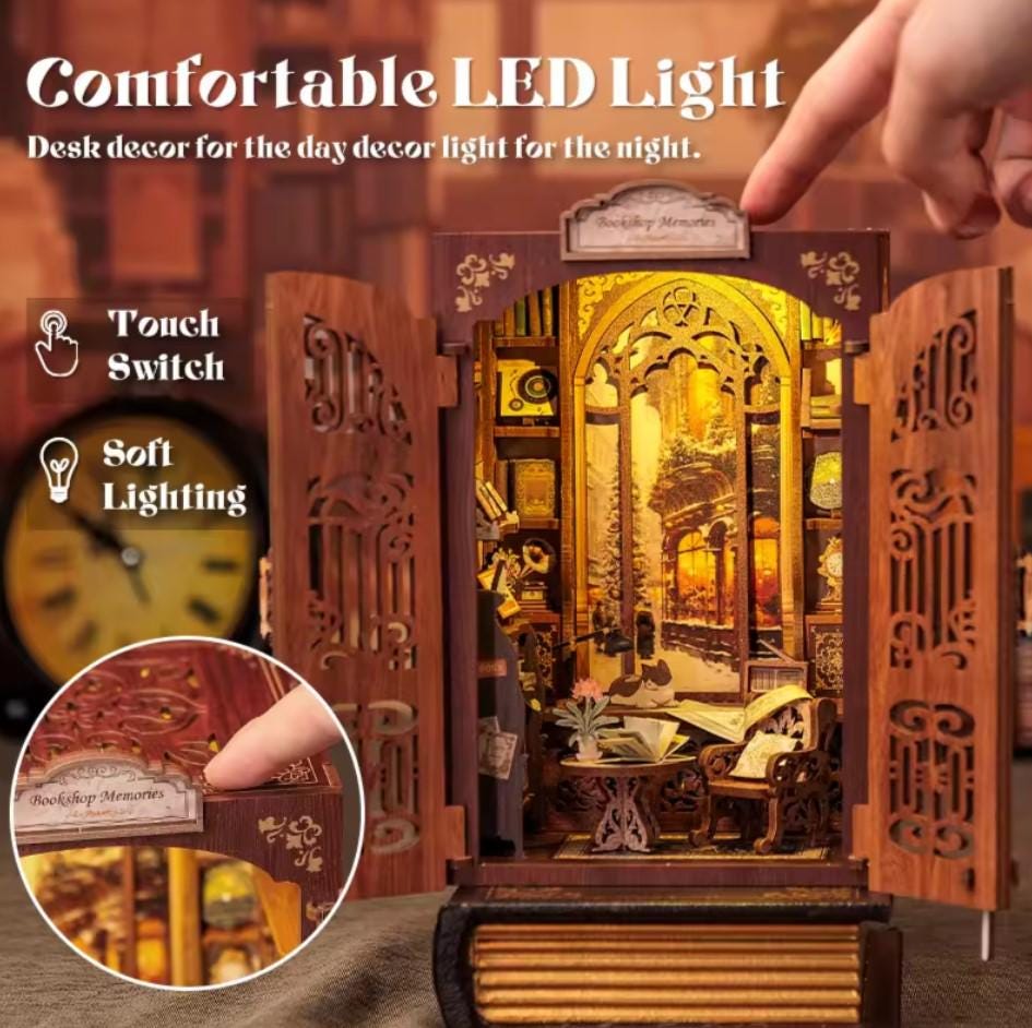 May include: A wooden book-shaped box with a miniature scene inside. The box is open, revealing a detailed miniature of a bookshop with a window, shelves, and furniture. The box has a touch-sensitive switch for soft lighting.