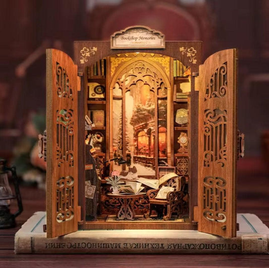 May include: A wooden miniature dollhouse with a bookshelf and a window view of a snowy street. The dollhouse is open and has a sign that reads "Bookshop Memories".
