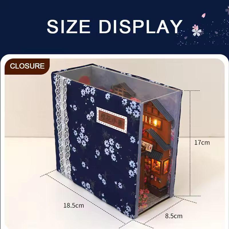 May include: A miniature Japanese-style house diorama, enclosed in a clear box with a navy blue floral patterned cover. The box measures 18.5cm x 8.5cm x 17cm. The diorama features a detailed facade with lit windows and a small garden.