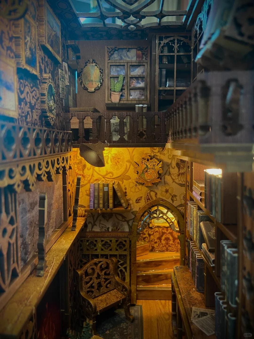 May include: A miniature wooden dollhouse with a detailed interior, featuring a library with bookshelves, a fireplace, and a staircase leading to an upper level. The dollhouse is decorated with intricate carvings and a warm, inviting atmosphere.
