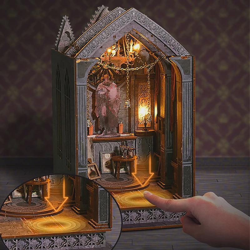 May include: A miniature, illuminated gothic cathedral model with intricate details. The interior features a statue, a small table, and a chandelier. The model is made of gray and brown materials, with a warm, inviting glow from the interior lights.