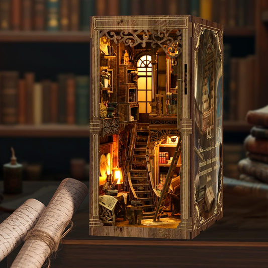 May include: A wooden book nook depicting a library interior with a staircase, bookshelves, and warm lighting. The detailed design includes a window and decorative features, creating a miniature, illuminated diorama. The book nook is made of wood.